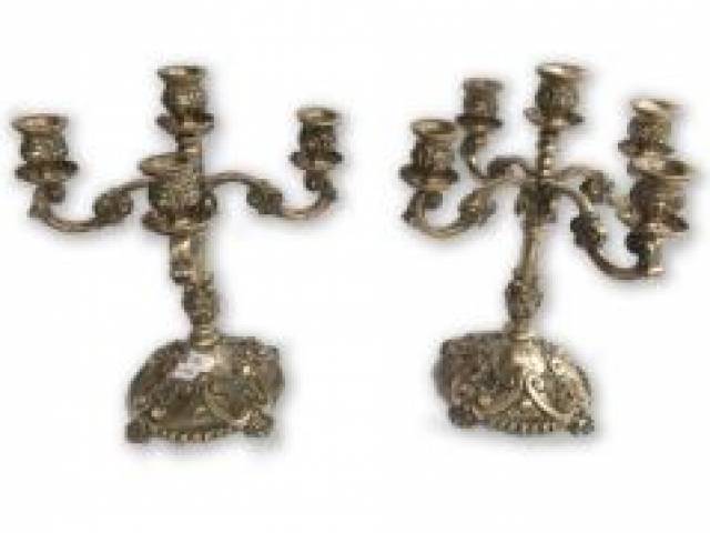 Maravilhoso par de candelabros em prata de lei repuxada e cinzelada finamente ornamentados ao estilo português para cinco velas com volutas e conchas. Hastes no formato de colunas encimadas por braços recurvos centralizando ponteiras, contraste Águia na base H = 30 cm e D = 18 cm cada, 3,5 Kg o par - Portugal