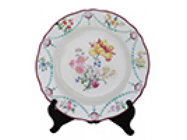 Prato em porc. “Mintons” borda bordô, centro e aba decor. com flores em cores alternadas e detalhes em alto relevo. d = 23 cm – Inglaterra