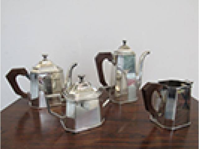 St. James - Serviço para café e chá contendo 4 peças: 1 bule para chá, 1 cafeteira, 1 açucareiro e 1 leiteira, metal espessurado a prata com laterais facetadas e alças em madeira . Marcado na base. Altura da maior 23 cm.