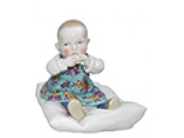 Julius Konrad Hentschel (1872-1907) Art Nouveau porc. Meissen “Criança sentada no travesseiro” esmaltada e vitrificada. 12 x 16 x 12 cm - Alemanha, séc. XX (1904).