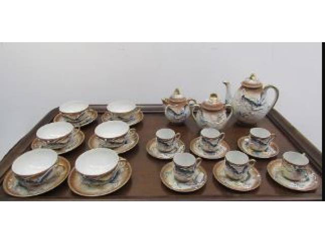 Satsuma - Aparelho para chá e café em fina porcelana japonesa "casca de ovo" decorada com figuras policromadas de dragões em alto-relevo e, ao fundo das xícaras, transparência, comemorativa ao aniversário da Imperatriz. Composto de 1 bule, 1 leiteira, 1 açucareiro, 6 xícaras (1 com pequeno bicado) para café com pires e 6 xícaras para chá com pires. Total de 15 peças. - Japão, anos 50