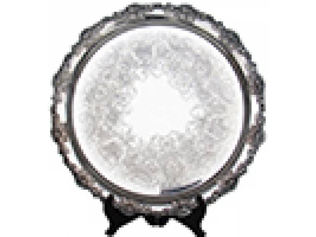 Salva em metal espessurado à prata, fundo lavrado, composições de arabescos, flores e volutas. Borda repuxada e cinzelada em formato de videiras em alto-relevo e três pés. d = 37 cm -Inglaterra, séc. XX