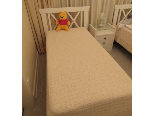 Cama de solteiro branca com espaldar vazado de madeira em forma de "X" acompanha colchão 185 x 85 x 60 cm. (objeto não faz parte deste lote, apenas o móvel)