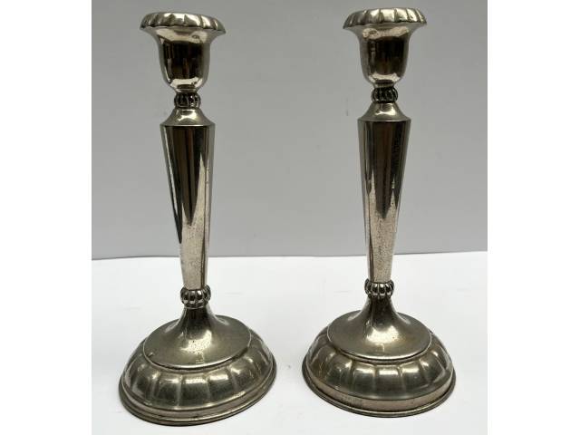 Par de castiçais em metal espessurado à prata com base canelada. Med.: 23cm