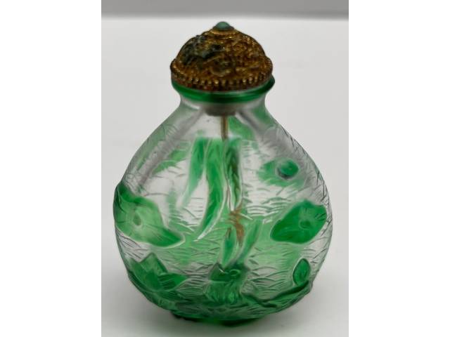 Snuff-Bottles em vidro transparente com relevo de ramos e flores na cor verde  com tampa dourada , peça de coleção. Med.: 6,5cm - China, séc. XVIII/XIX