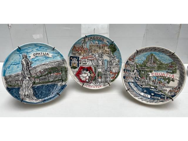 Kit com 3 pratos decorativos em cerâmica representando cidades da Croácia . Med. 14cm. Acompanha suporte de parede em metal.