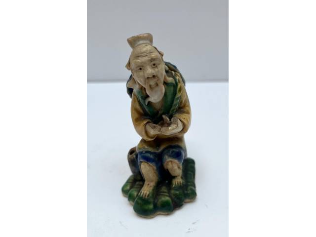 Escultura de cerâmica esmaltada chinesa decorada em policromia e moldada na representação de Ancião. Da metade do    séc. XX. Altura: 8cm